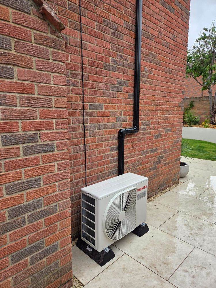 Outdoor unit against brickwork with the pipe run boxed in